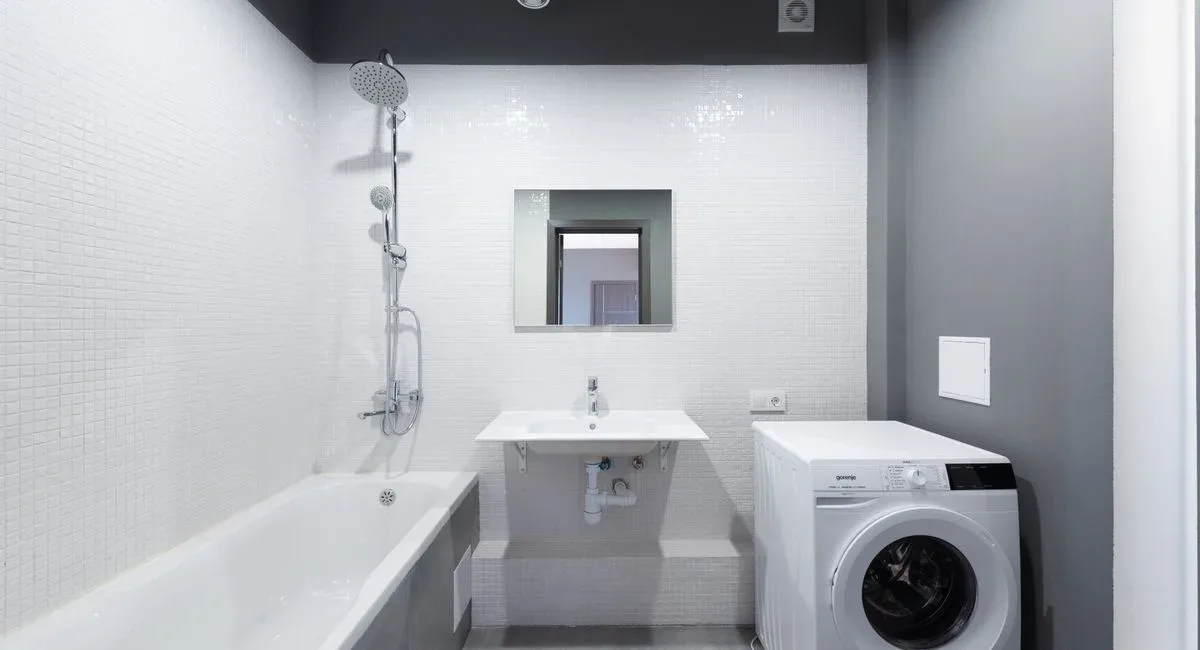 Salle de bain fonctionnelle avec rangements et revêtements clairs